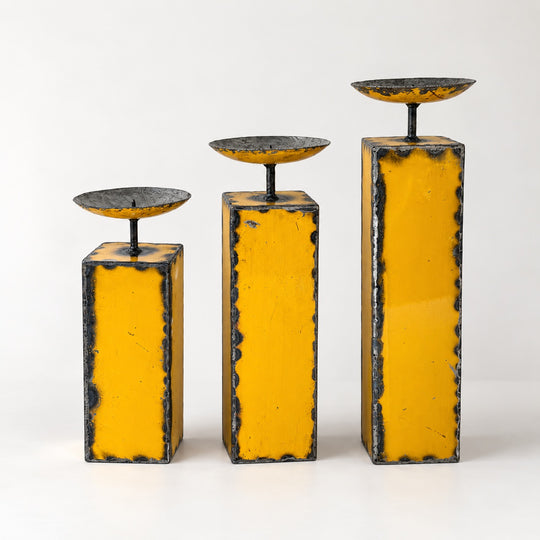 Trio de grands bougeoirs NURU en métal recyclé jaune, présentés par hauteur croissante sur fond clair.