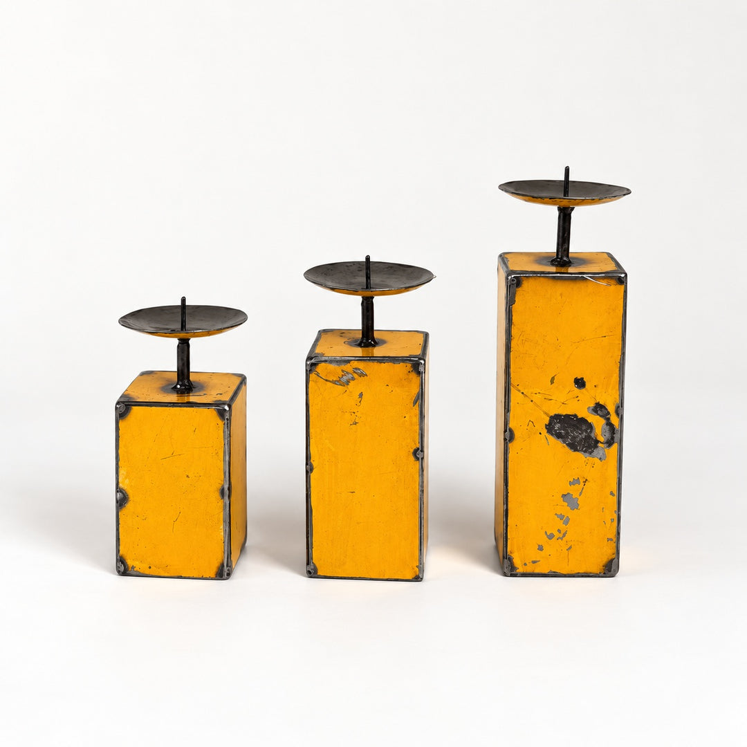 Trio de petits bougeoirs NURU en métal recyclé jaune, présentés par hauteur croissante sur fond clair.