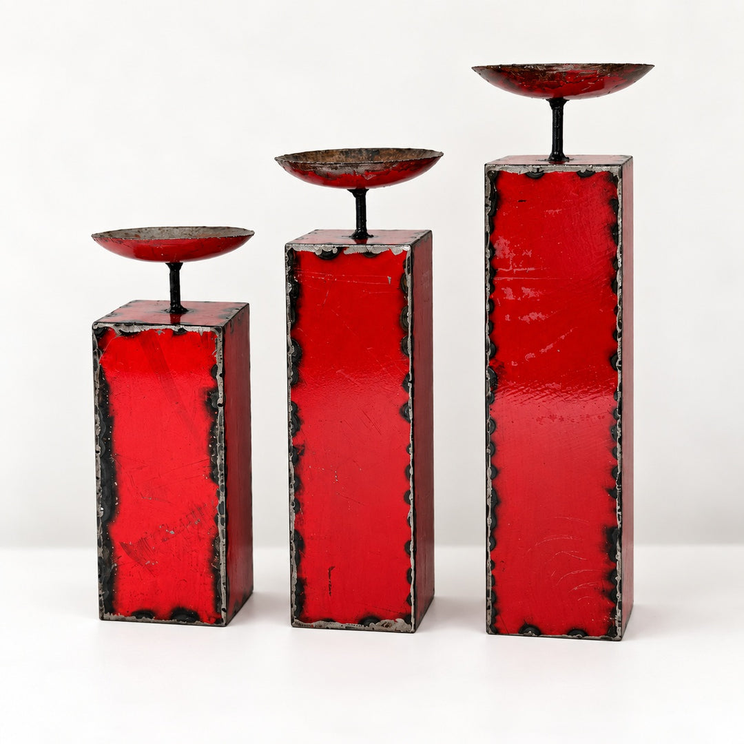 Trio de grands bougeoirs NURU en métal recyclé rouge, présentés par hauteur croissante sur fond clair.