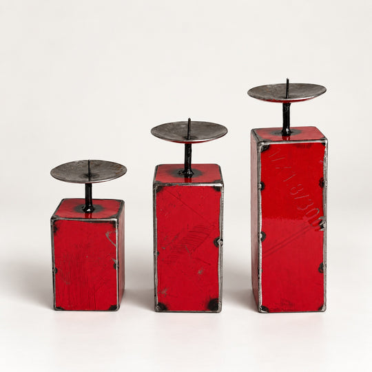 Trio de petits bougeoirs NURU en métal recyclé rouge, présentés par hauteur croissante sur fond clair.