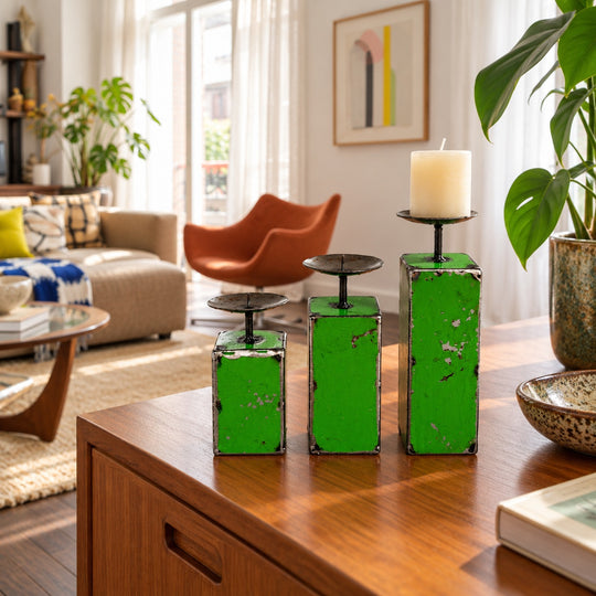 Trois bougeoirs NURU en métal recyclé vert sur un buffet en bois dans un salon vintage lumineux.