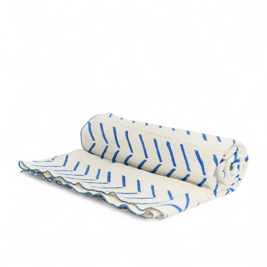 Au jardin, plaid FEMI-OKUN et housse de coussin en wax fleur de mariage bleu OSUN-UA en 40 x 60 cm. 