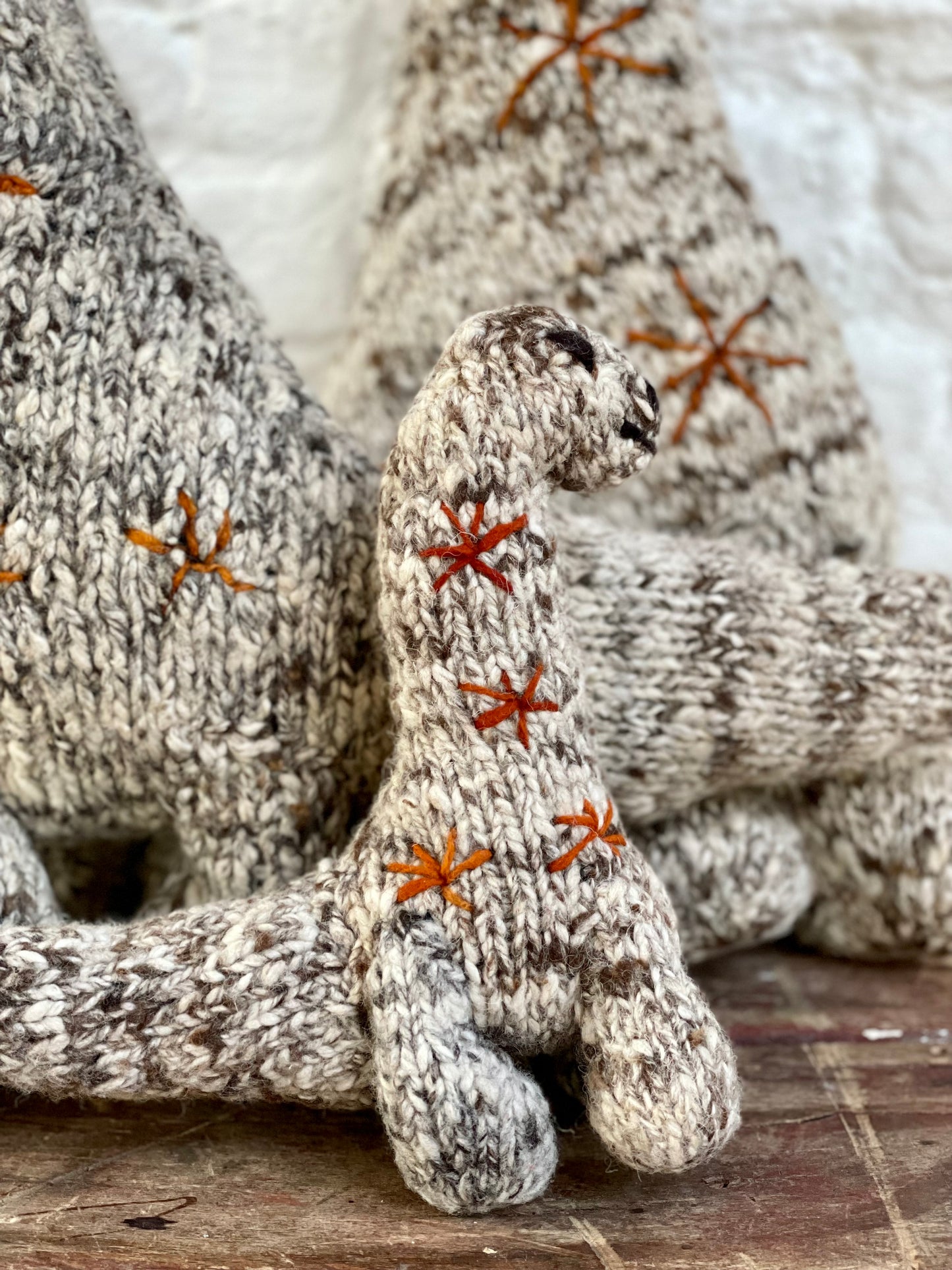 NESSIE, doudou brontosaure en laine mérinos. Fait main par les femmes artisans de la coopérative kenyane Kenana Knitters. Cette sympathique peluche dinosaure est disponible en 3 tailles. 