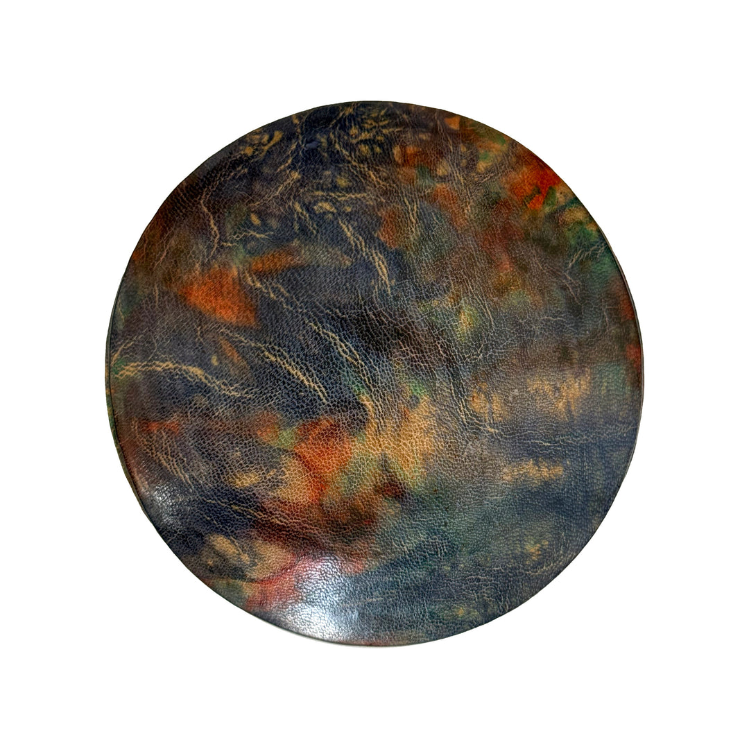 Couvercle rond en cuir marbré bleu, turquoise et orange, vu du dessus sur fond blanc.