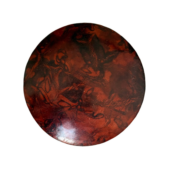 Couvercle rond en cuir marbré rouge rouille et brun, vu du dessus sur fond blanc.