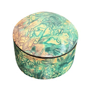 Boîte ronde en cuir marbré vert turquoise et beige, fermée et vue de trois quarts sur fond blanc.