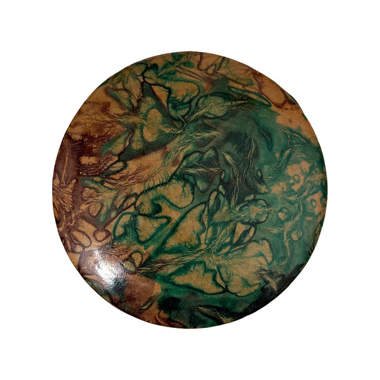 Couvercle rond en cuir marbré vert turquoise et beige, vu du dessus sur fond blanc.