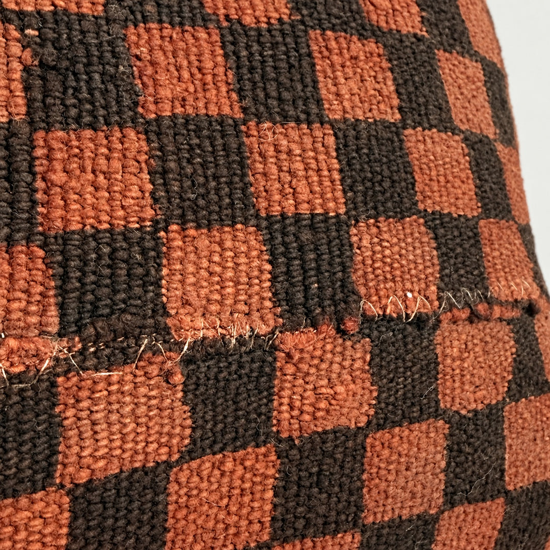 Detail des terrakottafarbenen TANDA Bogolans mit dunkelbraunem Schachbrettmuster, Webstruktur und Verbindungsnaht.