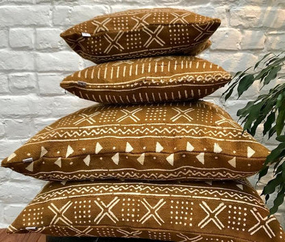 Housses de coussin ethniques 40cm x 40cm et 60cmx60cm, confectionnés en Belgique à partir de tissu africain bogolan ocre à motifs blancs. 100% coton tissé et teint à la main au Mali.